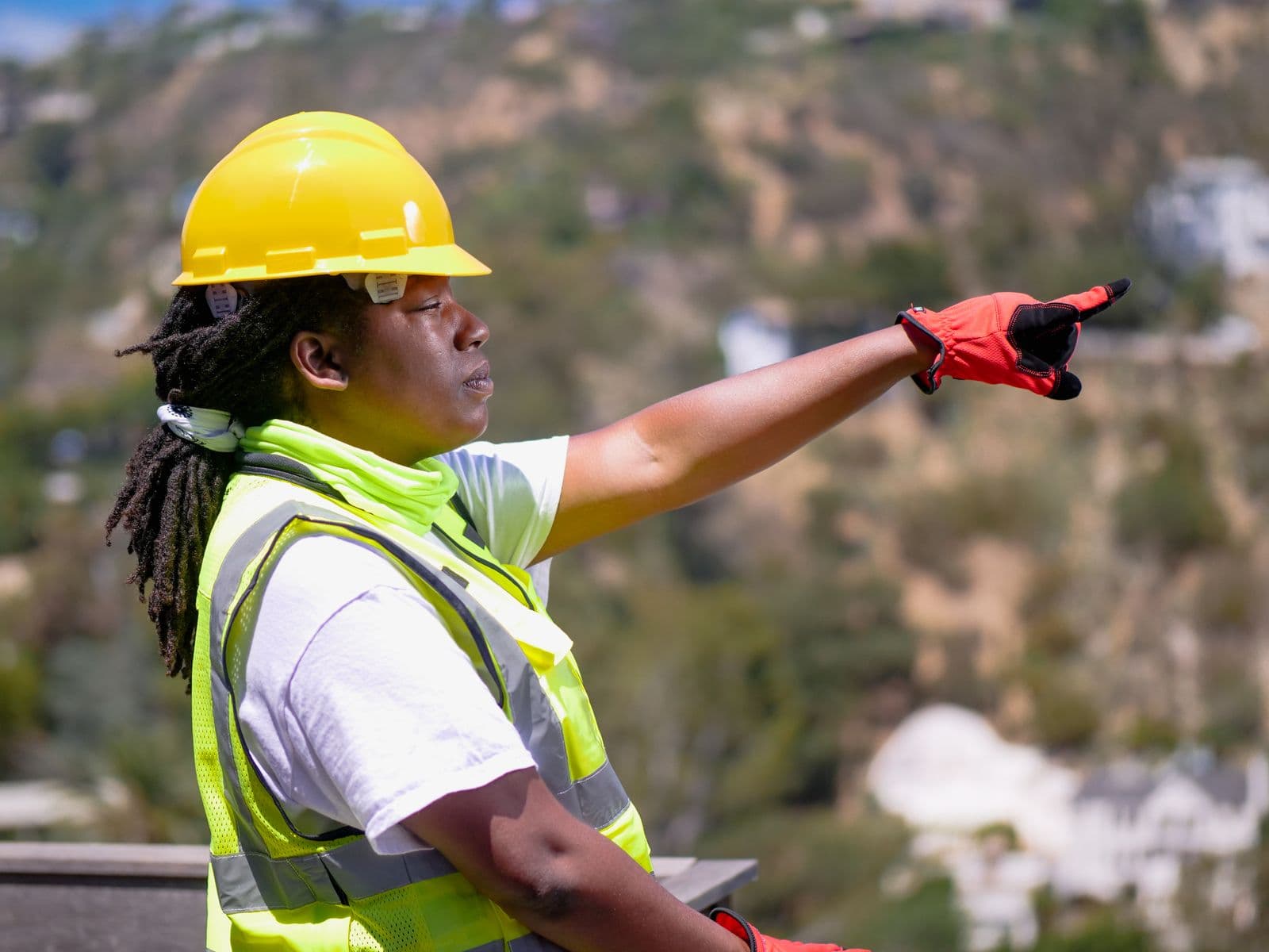 A site engineer in hi-vis directing work on a construction site