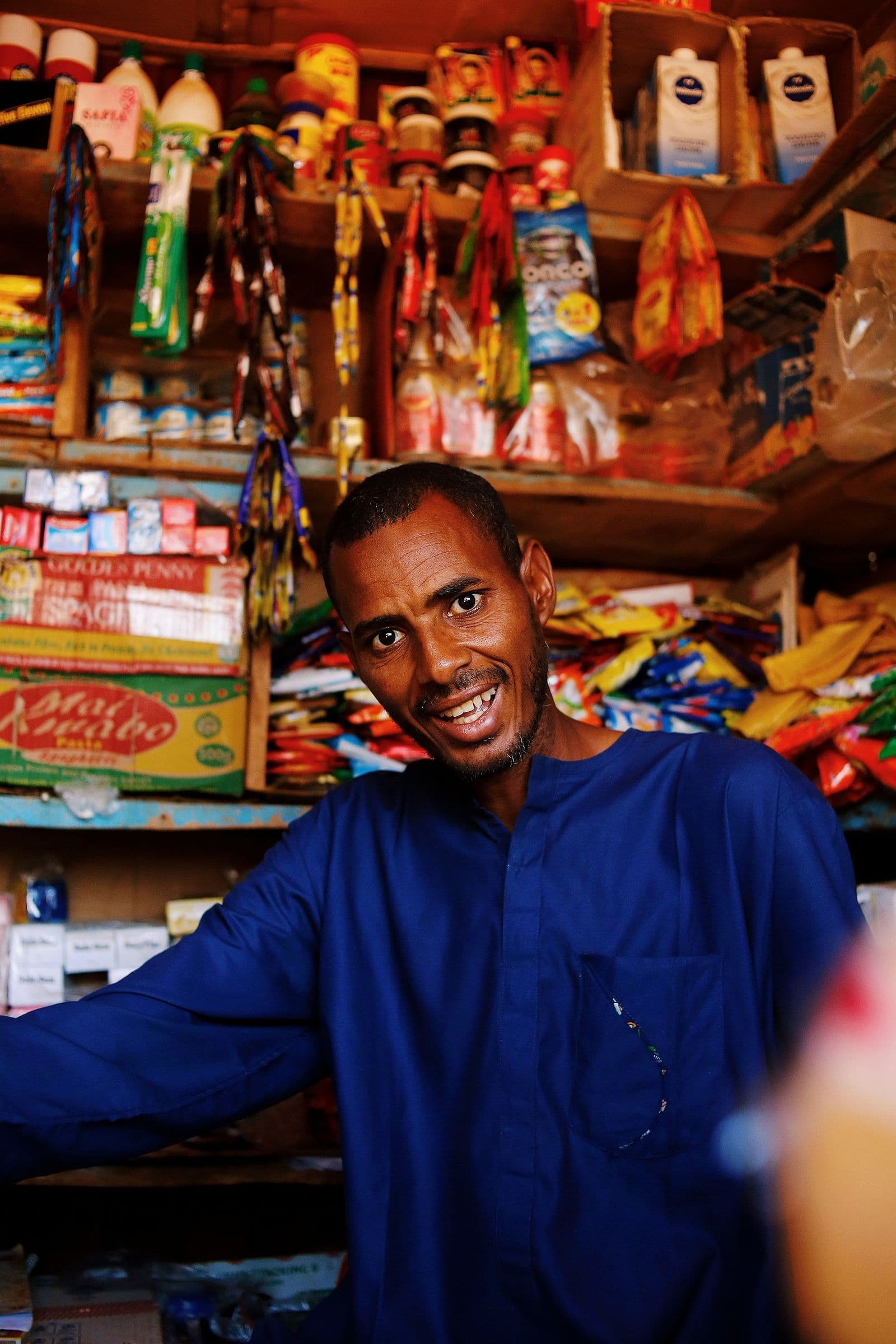 A shopkeeper in a stocked African retail store